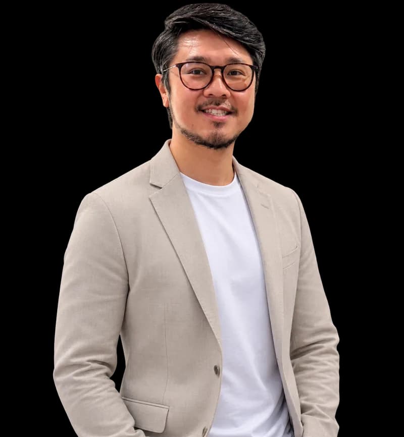Tam Nguyen, smiling, in a light tan blazer over a white t-shirt